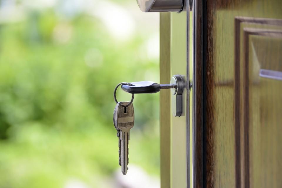Chave encaixada na fechadura de uma porta de madeira aberta